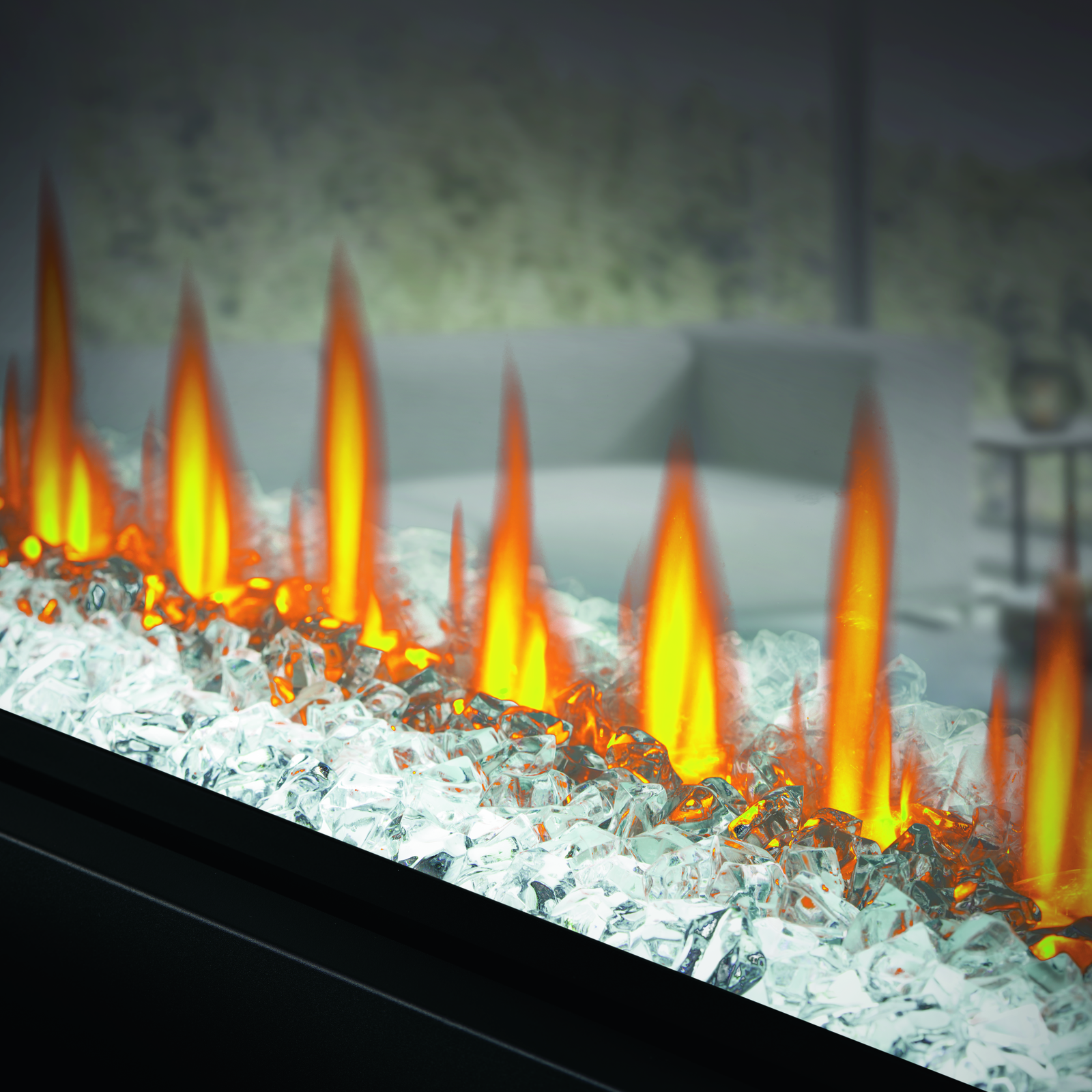 Electric fireplace with glowing flames and glass beads in a dimly lit room.
